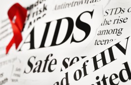 File: A red awareness ribbon on AIDS-related newspaper headlines. GettyImages/RapidEye