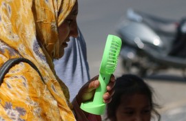 A woman is cooling off herself with a battery fan on a hot summer day in Srinagar. Firdous Nazir/NurPhoto via AFP