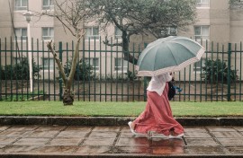 A woman walks through heavy rain in the city of Durban. AFP/Rajesh Jantilal