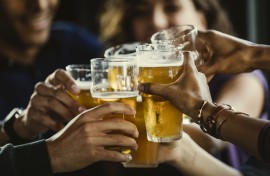 File: A group of friends toasting beer glasses. GettyImages/The Good Brigade