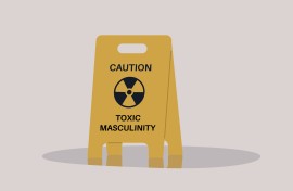 A yellow floor sign warning about toxic masculinity. GettyImages/nadia_bormotova