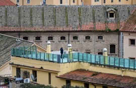 File: A prison guard (C) patrols a prison building's terrace overlooking the prison's wings, after smoke billowed from a rooftop of the Regina Coeli prison. AFP/Alberto Pizzoli