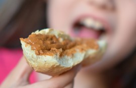 File: A girl bites into a sandwich. Hendrik Schmidt/dpa Picture-Alliance via AFP