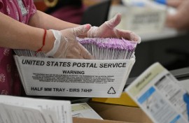 Election workers prepare mail-in ballots for tallying. AFP/Robyn Beck