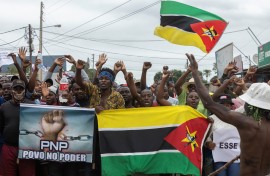 Protesters hold the Mozambican flag during a protest against the government in the Patrice Lumumba neighborhood in Maputo on November 6, 2024