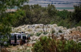 A SAPS vehicle near an opening to the mine shaft in Stilfontein. AFP/Phill Magakoe