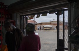 File: A street vendor speaks with a client as other clients gather in a spaza shop (informal supermarket) in Soweto, near Johannesburg, on November 12, 2024. 