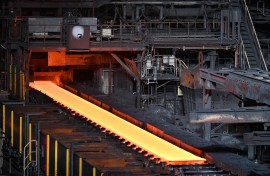 File: Steel moving along rollers at the hot rolling mill. AFP/Richard A. Brooks