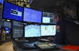 raders work on the floor of the New York Stock Exchange (NYSE). AFP/Angela Weiss