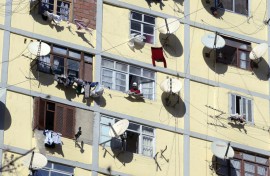 File: An apartment building full of satellite dishes on balconies. AP/Fayez Nureldine