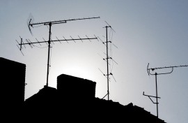 Television antennas can be seen in the evening light on roofs. Patrick Pleul/ dpa Picture-Alliance via AFP