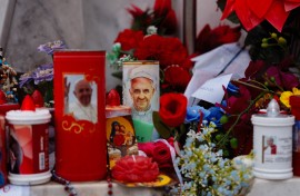 Candles and flowers are laid at the statue of John Paul II at the Gemelli University Hospital where Pope Francis is hospitalised with pneumonia. AFP/Dimitar Dilkoff