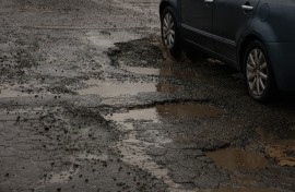 File: A vehicle driving through a pothole-ridden street. Nasir Kachroo/NurPhoto via AFP