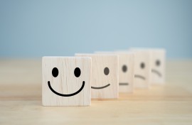Wooden blocks representing happiness and sadness. GettyImages/Wipada Wipawin