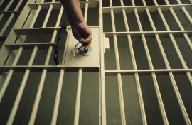 An officer locking a jail cell. GettyImages/Charles O'Rear