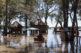 Workers navigate through the flooded accommodation and play areas in a row boat at Anchor Creek resort in Deneysville. AFP/Phill Magakoe