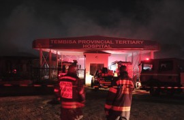 Firefighters stand outside the gate of the Tembisa Hospital after a fire broke out at the hospital’s accident and emergency unit. AFp/Emmanuel Croset