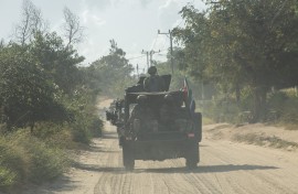 File: A military convoy of South Africa National Defence Forces (SANDF) rides along a dirt road. AFP/Alfredo Zuniga