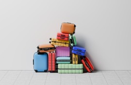 A large group of luggage stacked in a pile on top of each other. GettyImages/J Studios