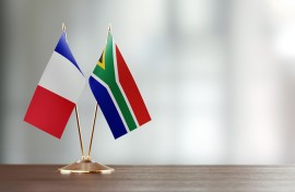 French and South African flag pair on desk. GettyImages/MicroStockHub