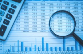 File: Spreadsheet bank accounts accounting with calculator and magnifying glass. GettyImages/echoevg
