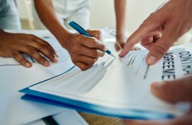 File: A person signing a contract agreement. GettyImages/skynesher