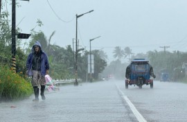 A man walks along a road amid heavy rain due to weather patterns from Super Typhoon Ragasa in Lal-lo town, Cagayan province. AFP/John Dimain