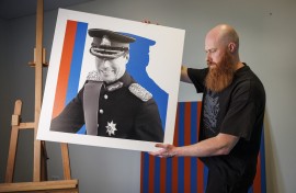 Pop artist Jacques Schneider carries an image of Grand Duke Henri of Luxembourg at his exhibition venue in Berchem. AFP/Simon Wohlfahrt