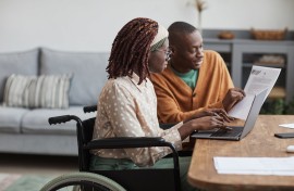 Woman in a wheelchair being assisted in a workplace