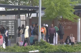 The stranded students sitting outside the gate.