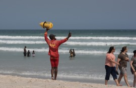A lifeguard directs people to move into the swimming zone. AFP/Rodger Bosch