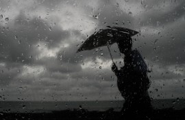 File: A man with an umbrella walking in the rain. Thilina Kaluthotage/NurPhoto via AFP