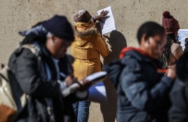 Unemployed people fill in the Department of Unemployment and Labour work seeking registration forms. AFP/Phill Magakoe