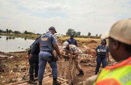 Police officers confiscate material used by artisanal miners from Gugulethu informal settlement. AFP/Phill Magakoe