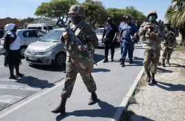 South African National Defence Force (SANDF) soldiers walk with South African Police Service (SAPS) officers in Mfuleni township in Cape Town on March 31, 2026.