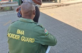 A border guard checking a woman's credentials. eNCA