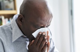 File: A man with a cold or flu blowing his nose. Frédéric Cirou/PhotoAlto via AFP