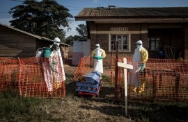 File: Medical workers disinfect the coffin of a deceased unconfirmed Ebola patient inside an Ebola Treatment Centre. AFP/John Wessels