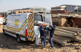 10 June_South African Police Service (SAPS) officers, along with forensic technicians, carry a victim’s body into a forensic pathology service vehicle at Jumpers informal settlement in Cleveland, east of Johannesburg, on June 10, 2026.