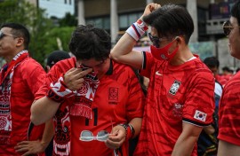 South Korean fans react after their team lost the 2026 World Cup football match against South Africa at Gwanghwamun Square in Seoul on June 25, 2026. (Photo by Jade GAO / AFP)