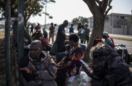 Malawian undocumented migrants sit in a shaded area in Durban. AFP/Marco Longari