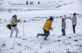 A family gathers to play in snow on Nottingham Road near Pietermaritzburg on 10 August. Photo by RAJESH JANTILAL / AFP