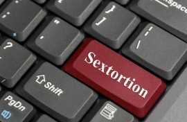 The word sextortion on a keyboard. GettyImages/payphoto