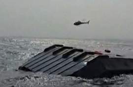 A helicopter circling the capsized ferry. AFP/UCG