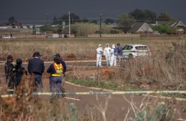 Members of the South African Police Service (SAPS) Forensic Pathology Services work on the crime scene where the body of a woman was discovered in Boksburg on September 17, 2026.