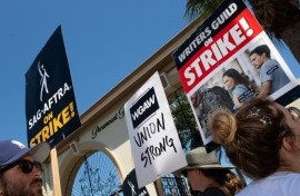 Members of the Writers Guild of America and the Screen Actors Guild walk a picket line outside of Paramount Pictures