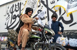 Vendors sell flags of the Islamic Emirate of Afghanistan -- the name given to the country by its new rulers -- in the capital Kabul ahead of the anniversary of the Taliban takeover 