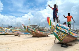 Young boys play on pirogues like the one that was found this week off Cape Verde with more than 60 passengers feared dead