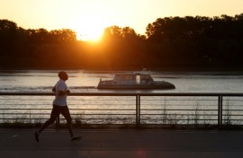 A man jogs along the docks at sunrise to avoid the heat, in Bordeaux, southwestern France