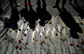 People observe a memorial with the names of the Chilean dictatorship victims during a ceremony to commemorate the 50th anniversary of the Chilean dictatorship in front of La Moneda Presidential Palace in Santiago, on September 11, 2023